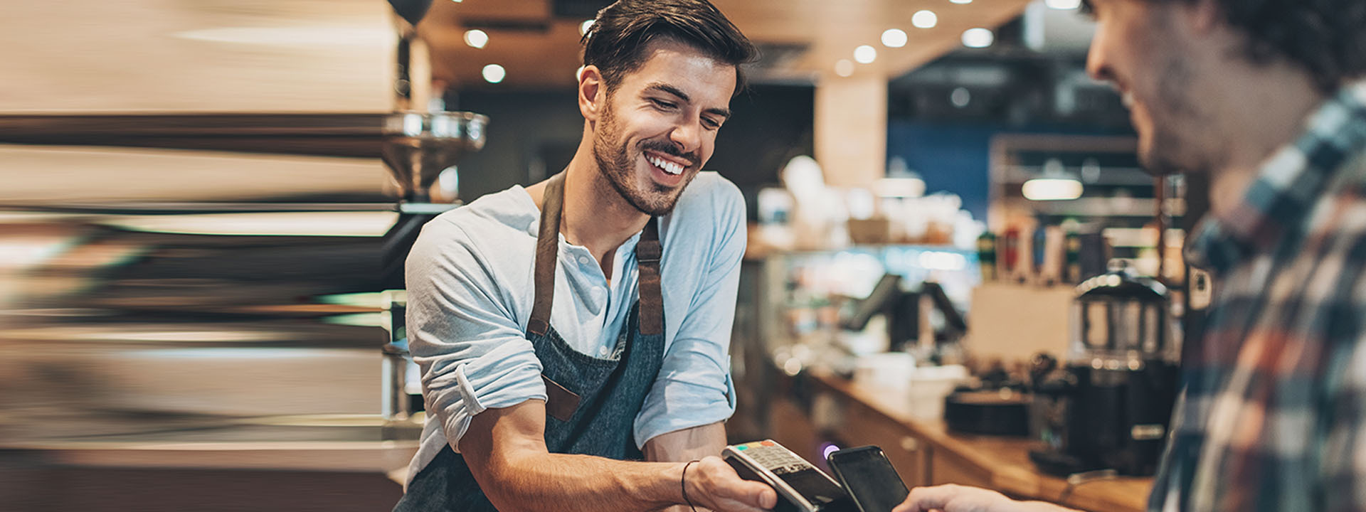 Hombre sonriente recibiendo un pago contactless