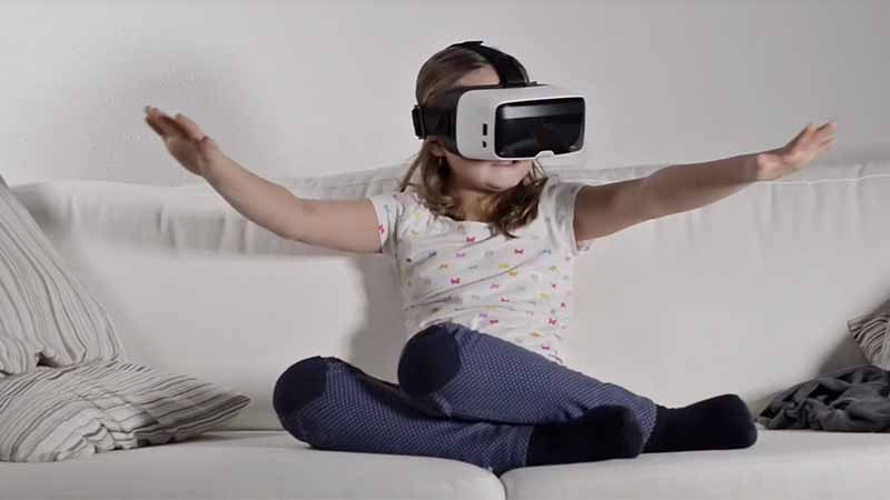 Niña jugando con máscara de realidad virtual